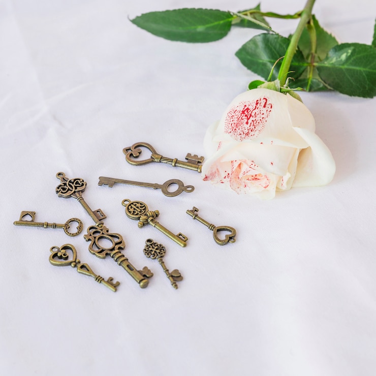Foto gratuito rosa blanca pintada con pequeñas llaves en mesa.