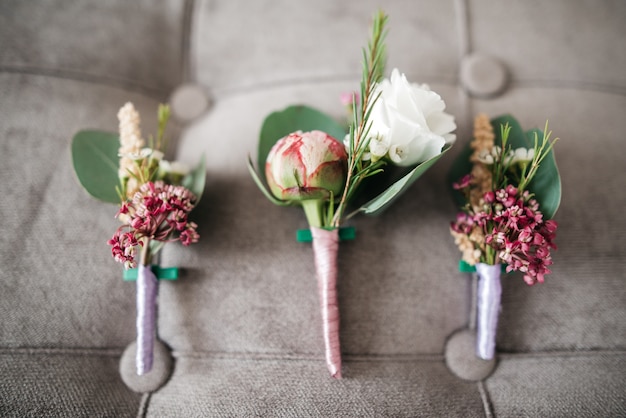 Foto gratuita rosa boutonnieres mentir en el sofá gris