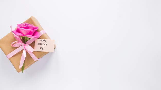 Rosa con caja de regalo e inscripción feliz dia de las madres.