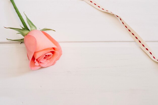 Rosa y encaje blanco y rojo sobre una mesa de madera