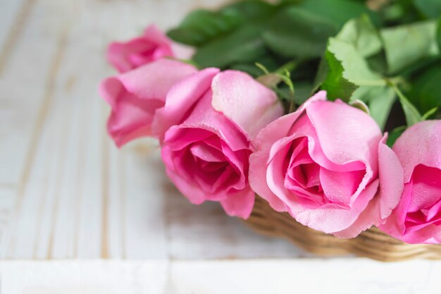 Rosa fresca rosa sobre fondo blanco de madera