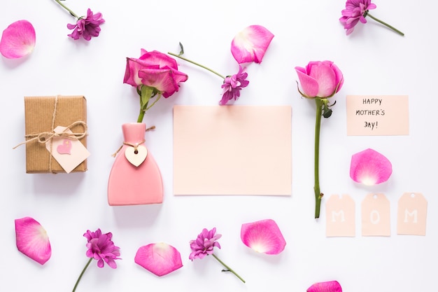 Foto gratuita rosa en jarrón con papel e inscripción feliz día de la madre.