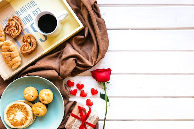 Foto gratuita rosa y presente cerca del desayuno