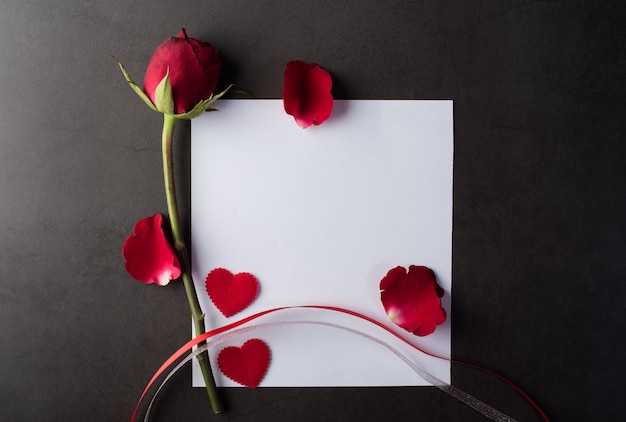 Foto gratuita rosa roja con tarjeta blanca