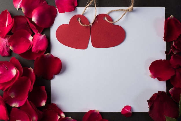 Foto gratuita rosa roja con tarjeta blanca