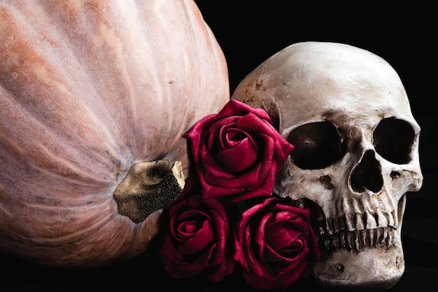 Foto gratuita rosas con calavera humana y calabaza