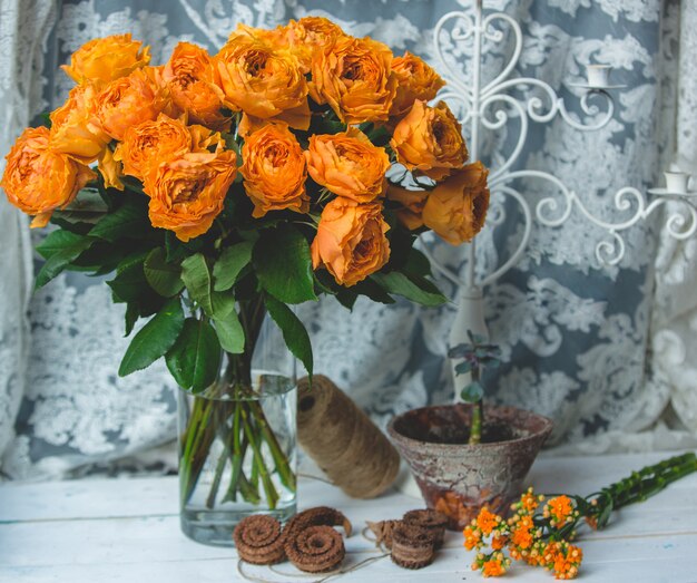 Rosas de color naranja en una jarra con agua