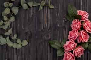 Foto gratuita rosas y hojas en la mesa de madera