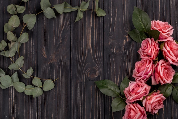 Rosas y hojas en la mesa de madera