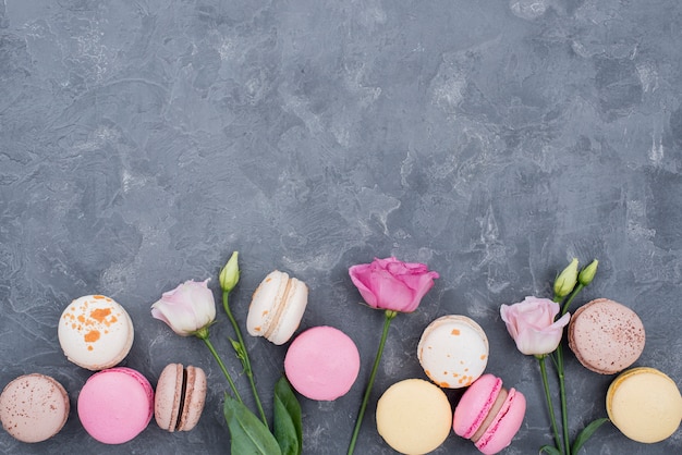 Foto gratuita rosas con macarons y espacio de copia