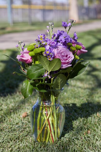 Rosas moradas con hojas verdes en el florero