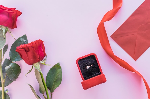 Foto gratuita rosas rojas con anillo de bodas en caja sobre mesa