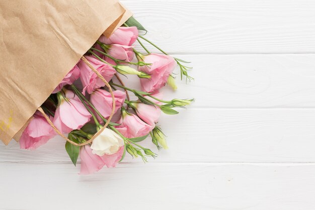 Rosas rosadas en una bolsa de papel con espacio de copia