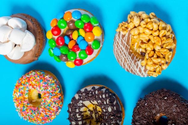 Foto gratuita rosquillas surtidas sobre un fondo azul.