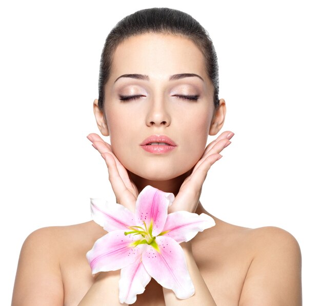 Rostro de belleza de mujer joven con flor.