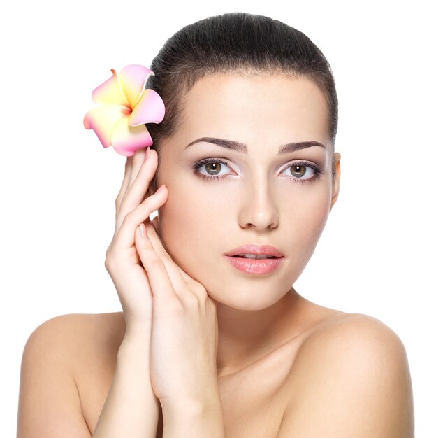 Rostro de belleza de mujer joven con flor.