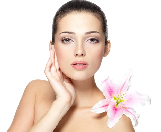 Rostro de belleza de mujer joven con flor.