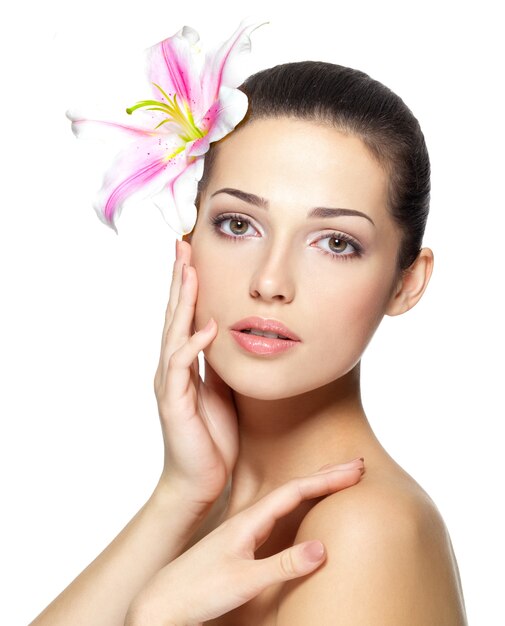 Rostro de belleza de mujer joven con flor.