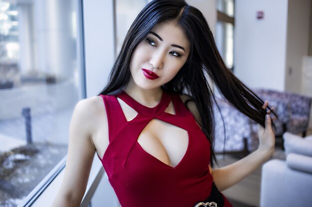 rostro femenino modelo asiático. vistiendo lápiz labial rojo y vestido de moda