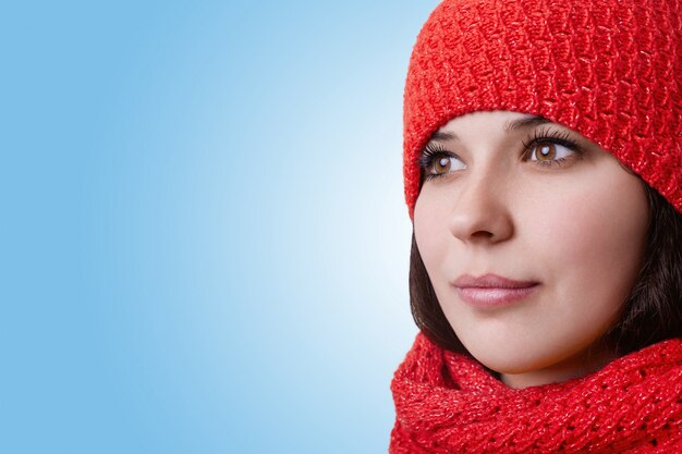 Rostro de una mujer atractiva. Bastante joven con grandes ojos marrones con pestañas largas y labios expresivos con sombrero rojo