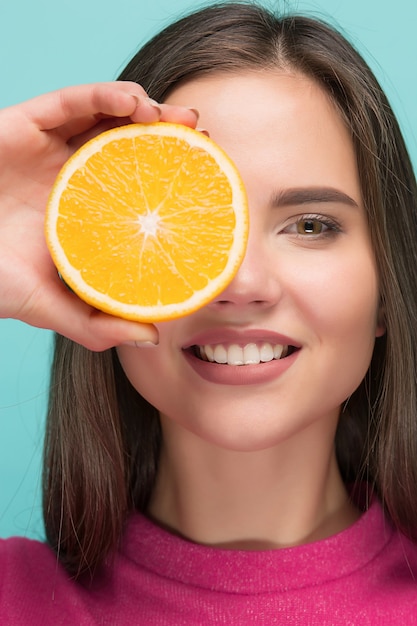 Rostro de mujer hermosa con jugosa naranja