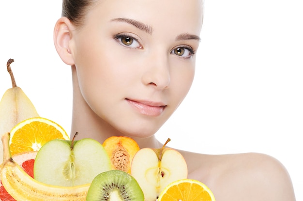 Rostro de mujer joven con frutas frescas aisladas en blanco