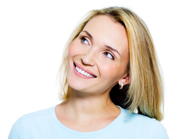 Rostro de una mujer pensativa sonriente mirando hacia arriba - aislado en blanco