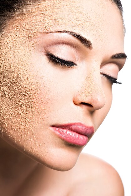 Rostro de una mujer con polvo cosmético en la piel - aislado en blanco