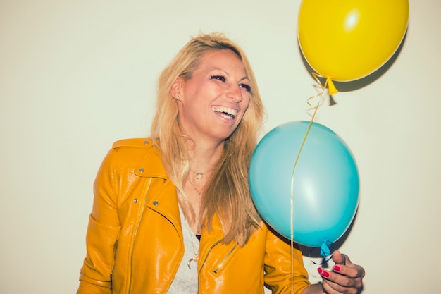 Rubia feliz con globos riéndose