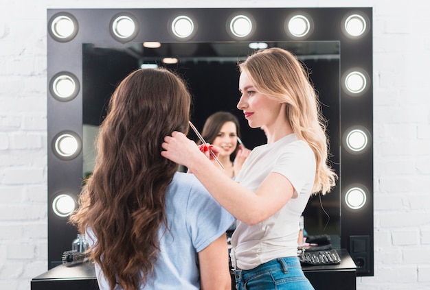 Foto gratuita rubia haciendo maquillaje de ojos para cliente con cepillo