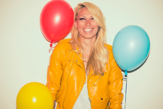 Rubia sonriente posando con globos