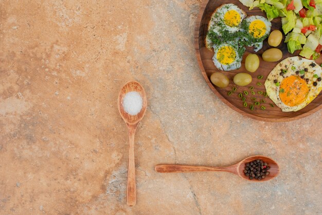 Sabrosa ensalada con huevos sobre tabla de madera.