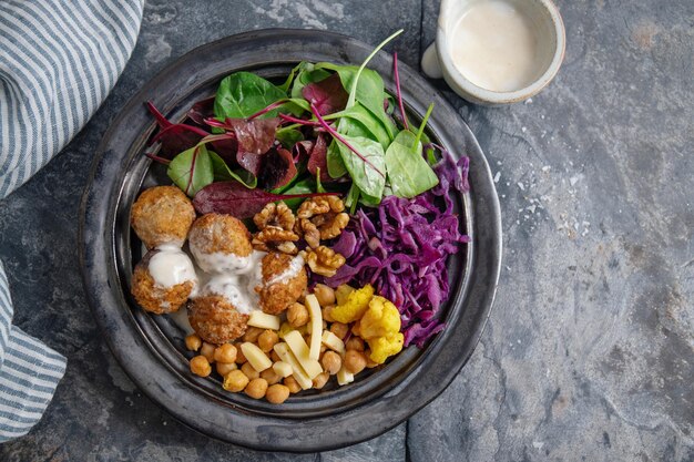 Foto gratuita sabrosa ensalada vegetariana vegana con falafel de garbanzos y hojas servidas en un plato