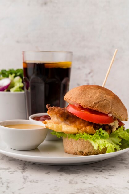 Sabrosa hamburguesa casera con salsa y refresco