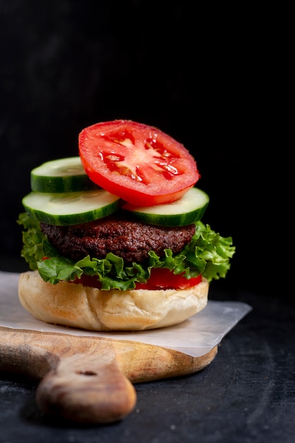 Sabrosa hamburguesa en tablero de madera