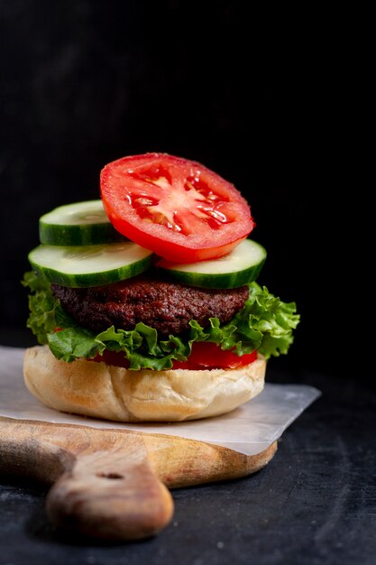 Sabrosa hamburguesa en tablero de madera