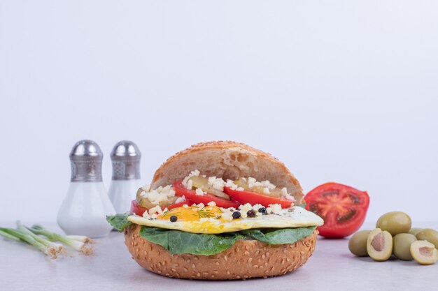 Sabrosa hamburguesa con tomate, queso, lechuga en blanco.