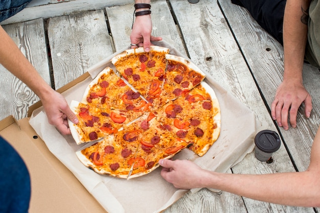 Sabrosa pizza en caja sobre superficie de madera