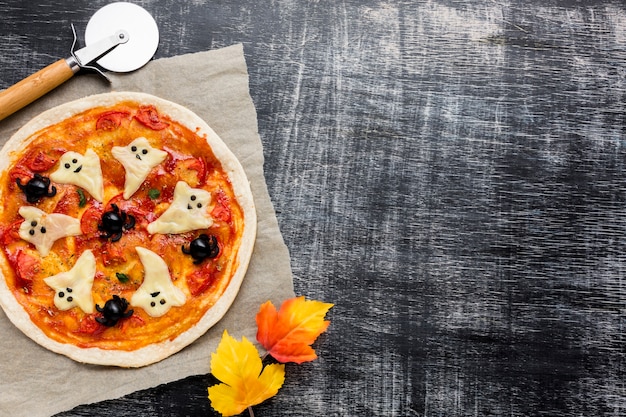 Foto gratuita sabrosa pizza de halloween con hojas de otoño