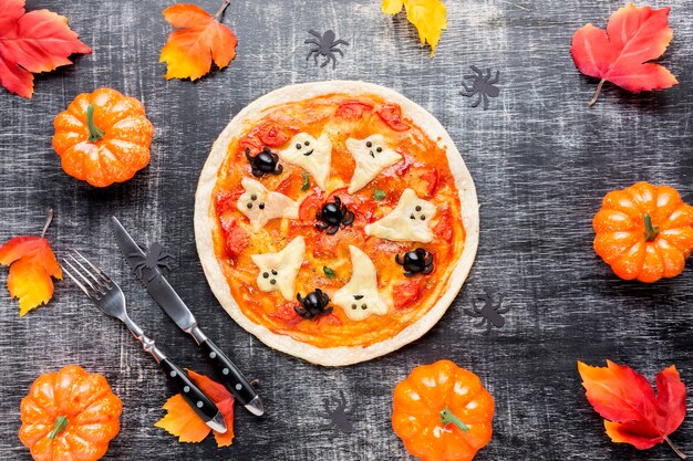 Sabrosa pizza rodeada de elementos de halloween