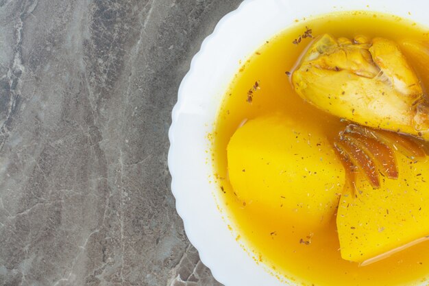 Sabrosa sopa con carne de pollo y patatas en un plato blanco.