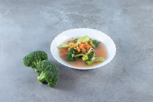 Sabrosa sopa de pollo en un bol, sobre la superficie de mármol.