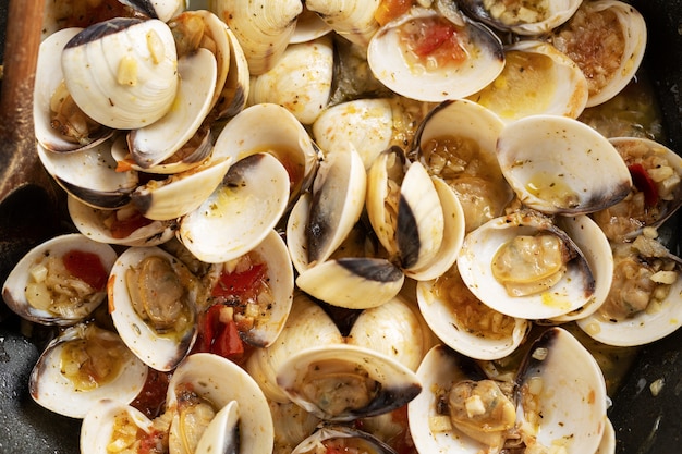 Sabrosas apetitosas almejas caseras frescas alle vongole con ajo y vino blanco en sartén. De cerca.