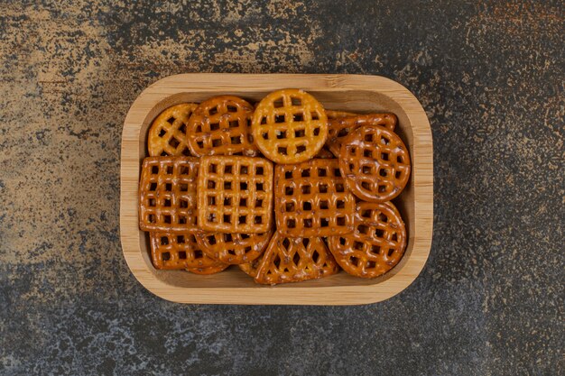 Sabrosas galletas crujientes en placa de madera.