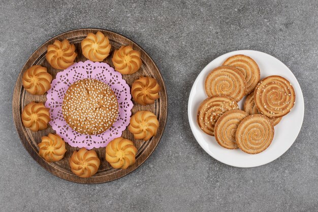 Sabrosas galletas dulces y galletas sobre tabla de madera.