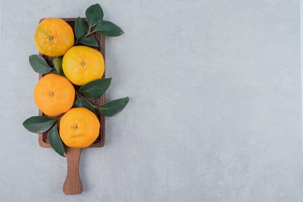 Sabrosas mandarinas frescas en tablero de madera