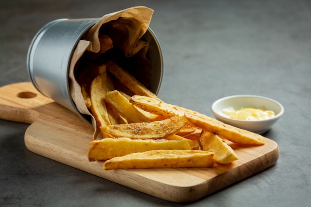 Sabrosas papas fritas sobre fondo oscuro