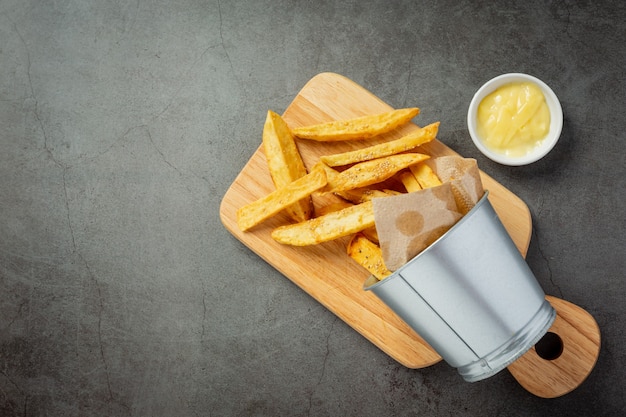 Sabrosas papas fritas sobre fondo oscuro