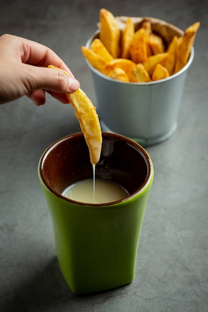 Foto gratuita sabrosas papas fritas sobre fondo oscuro