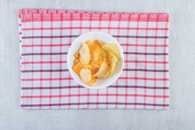 Sabrosas patatas fritas crujientes colocadas en un tazón blanco con mantel.